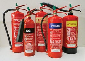 an arrangement of fire extinguishers of different sizes and kinds