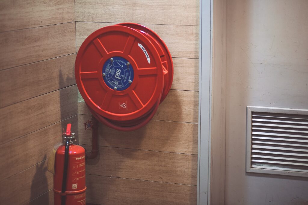 a fire extinguisher and fire hose mounted beside a door